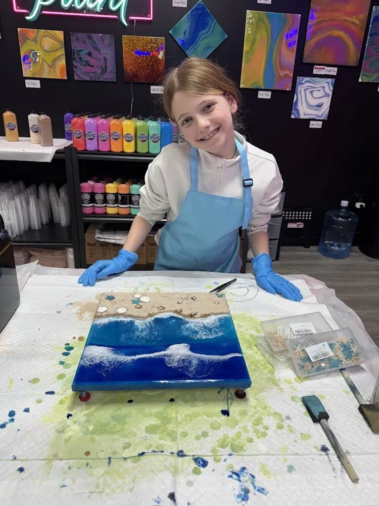 Child creating fluid art with vibrant colors in Hawaii